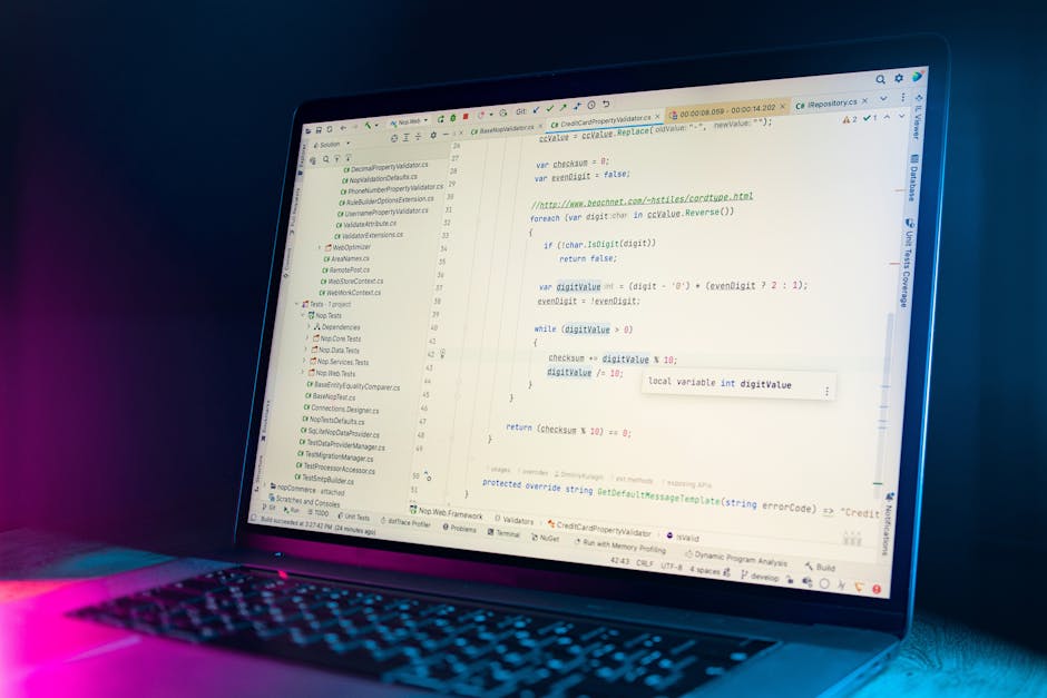 Close-up of an open laptop displaying lines of code on a dark background, situated on a wooden desk beside a ceramic coffee mug with black text that reads 'This coffee is maker me awesome.' In the bac